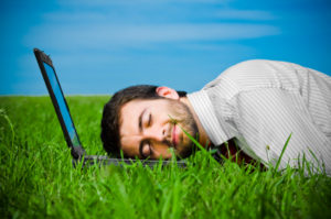man resting his head on laptop